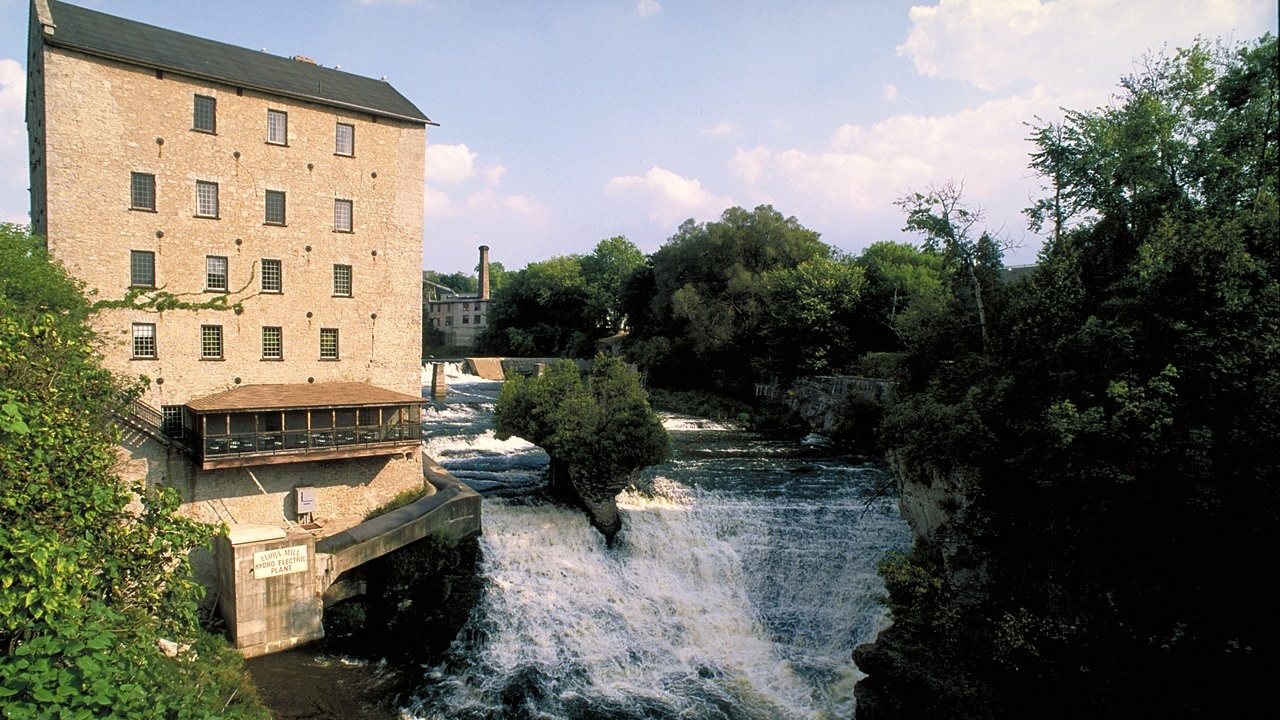 View of Elora Mill Inn & Spa and waterfalls on river Destination Ontario EHRICHT best small towns in Ontario