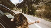 Travel with adult children showing woman leaning out of car window
